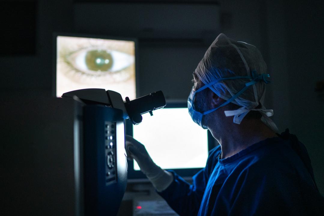 Surgeon looking at an eye through specialist imaging equipment