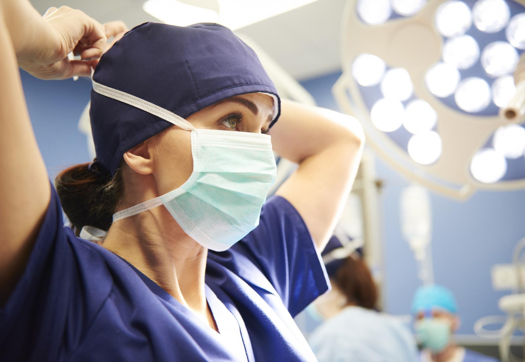 Female health professional tying a surgical mask