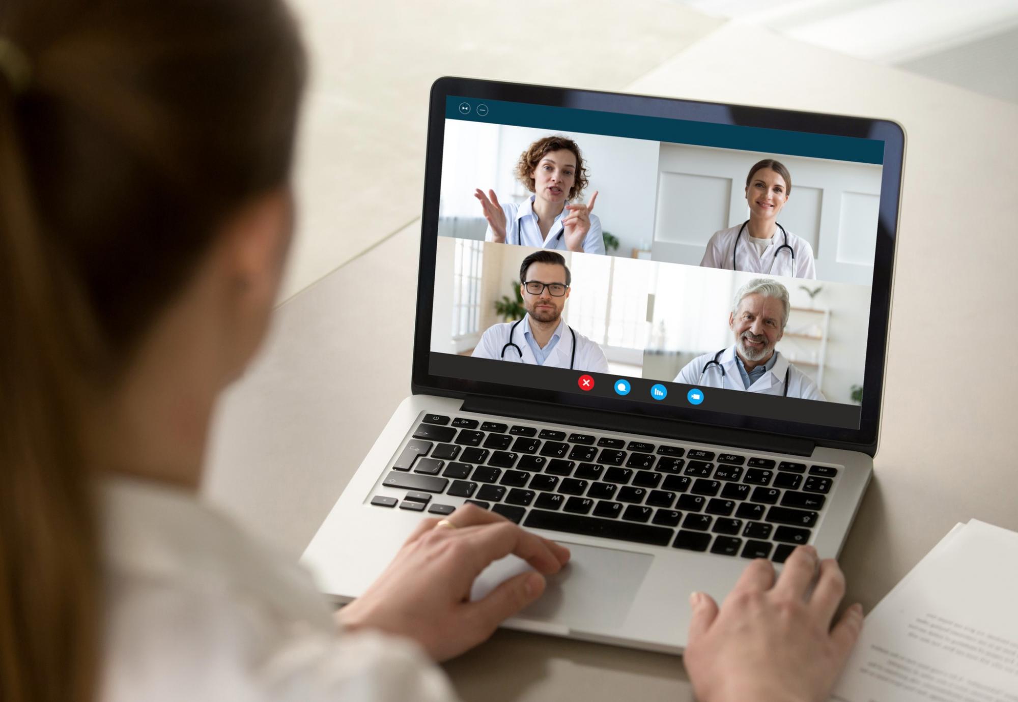 Doctor using a laptop to communicate virtually with colleagues