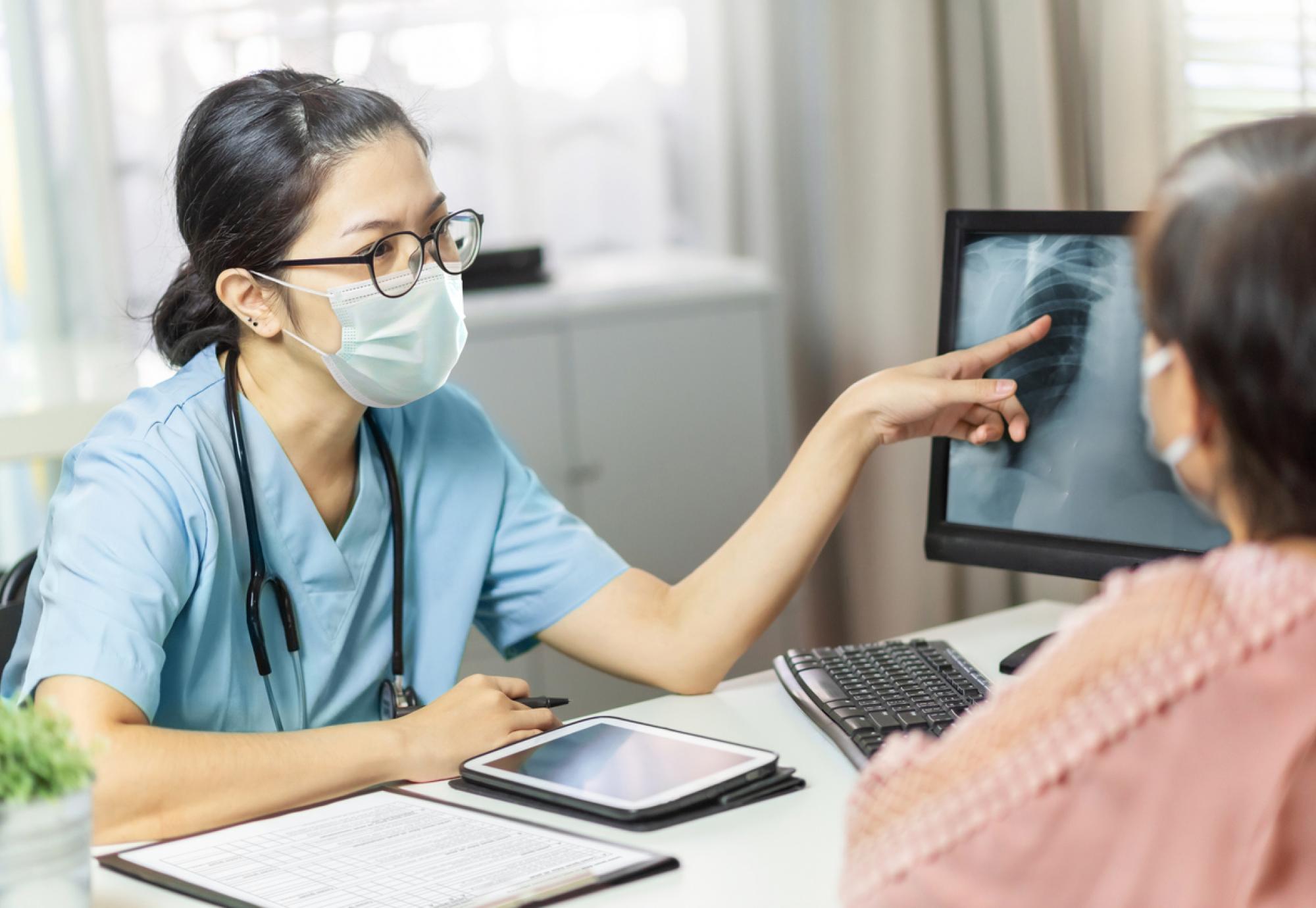 doctor speaking with patient pointing at computer screen