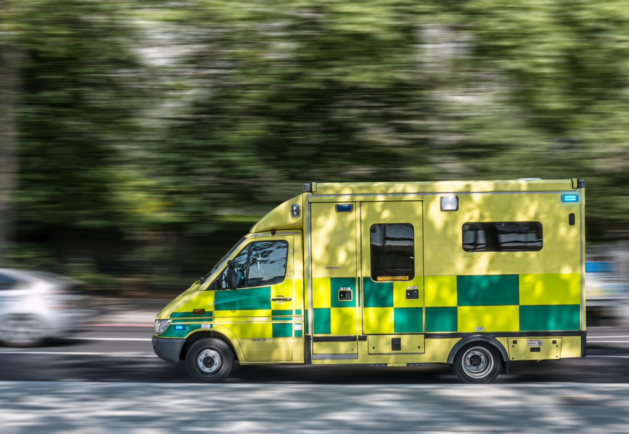 Image of an ambulance on the road depicting the NHS mobile liver cancer testing trucks