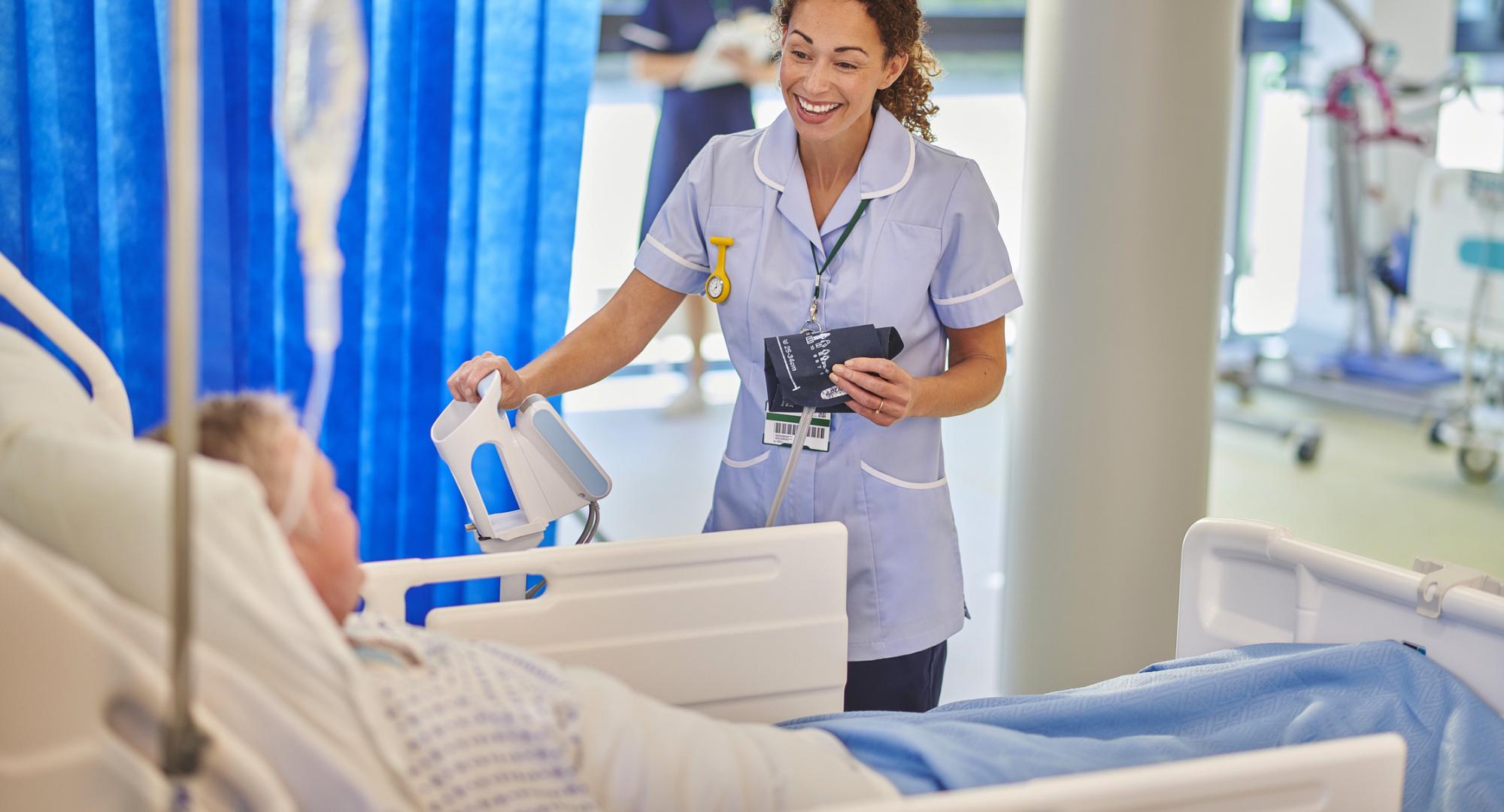 nurse chatting to patient on hospital ward