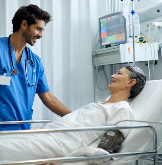 Male health professional at the bedside of a patient