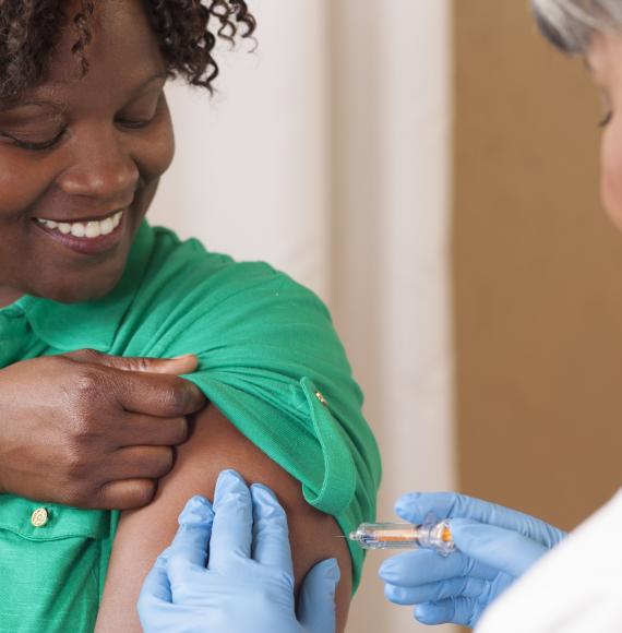 Woman receives a vaccination injection from health professional
