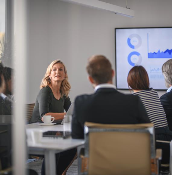 Female leader in conversation with colleagues during a board meeting