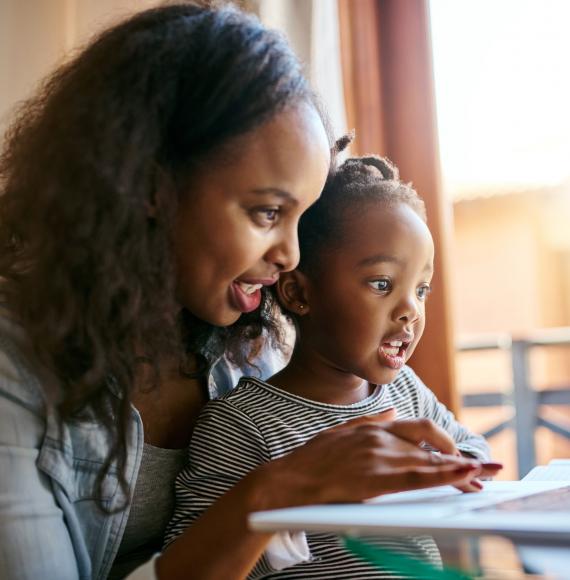 Young mother and her child looking at something on a laptop