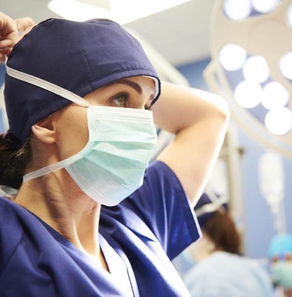 Female health professional tying a surgical mask