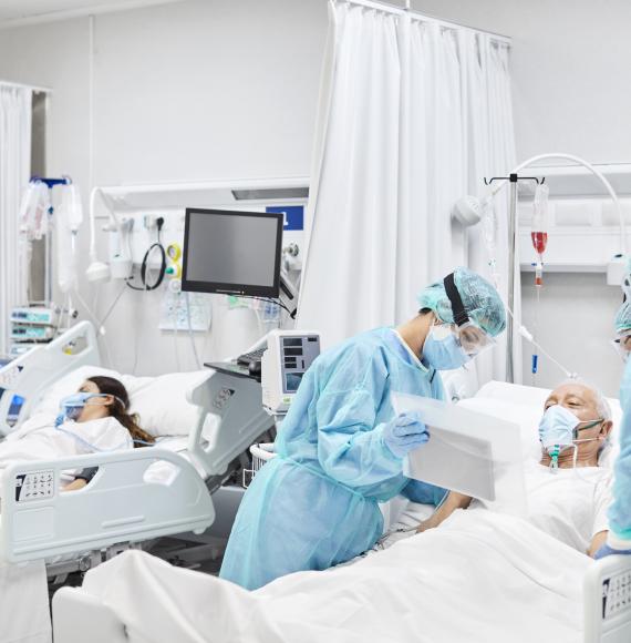 Health professionals in PPE treat patients in a hospital ward