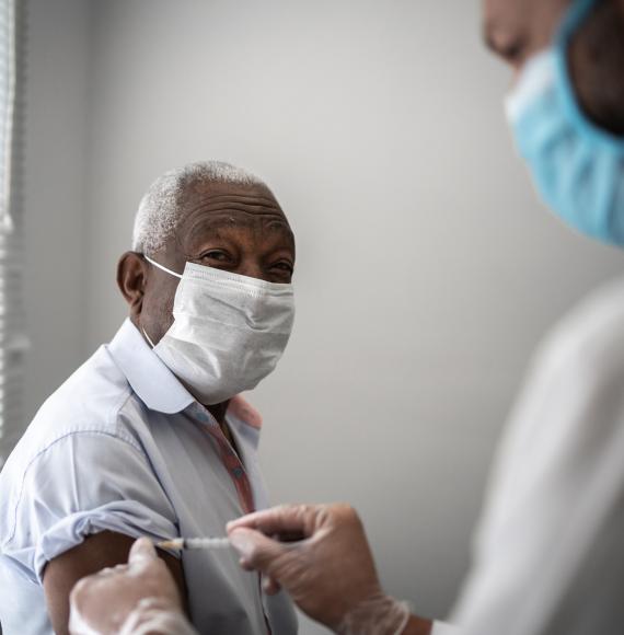Elderly man receives a vaccine jab