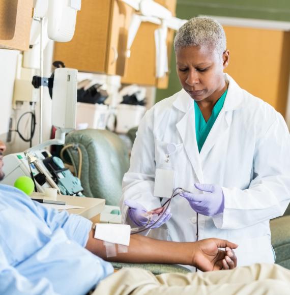 Male patient donating plasma with health professional observing
