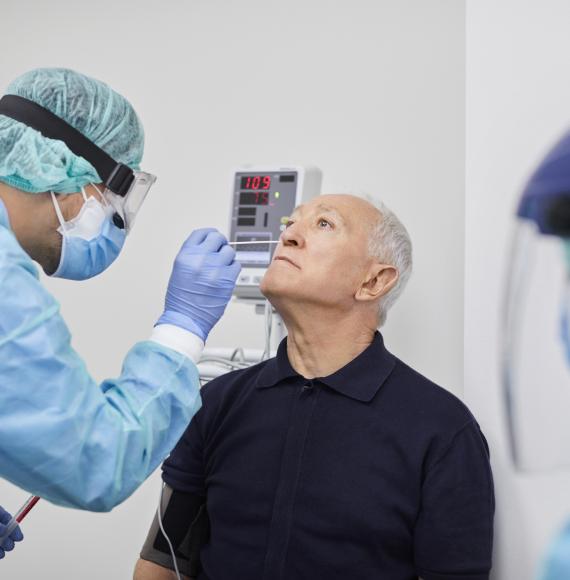 Medical professional performing a Covid test on an elderly patient