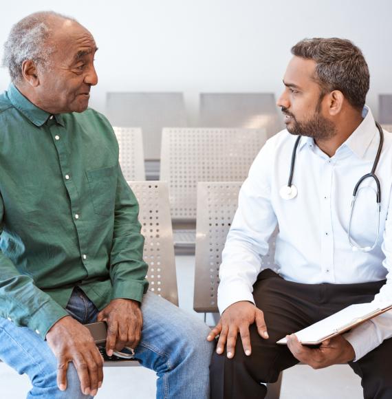 Man of South Asian descent talking with a doctor