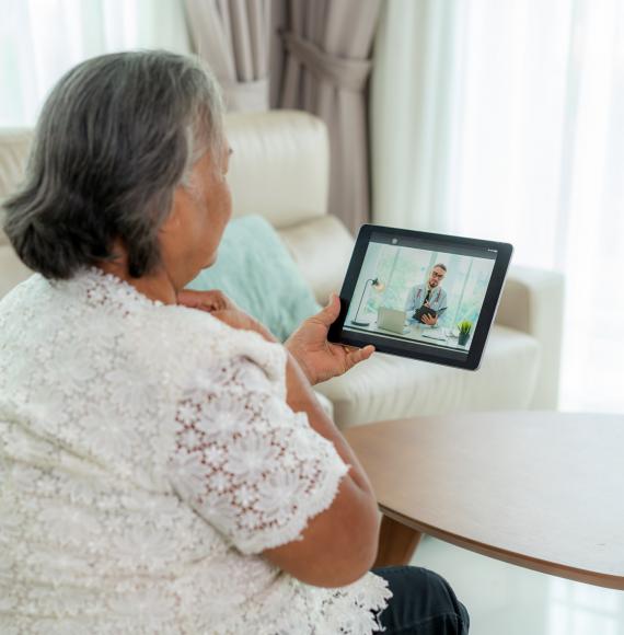 Elderly woman in conversation with a doctor on a tablet PC
