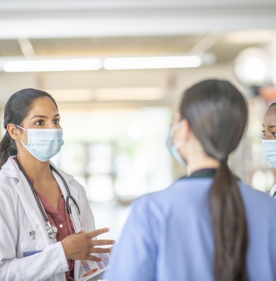 Medical professionals discussing while on a ward