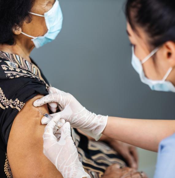 Health professional administering vaccine jab to a patient