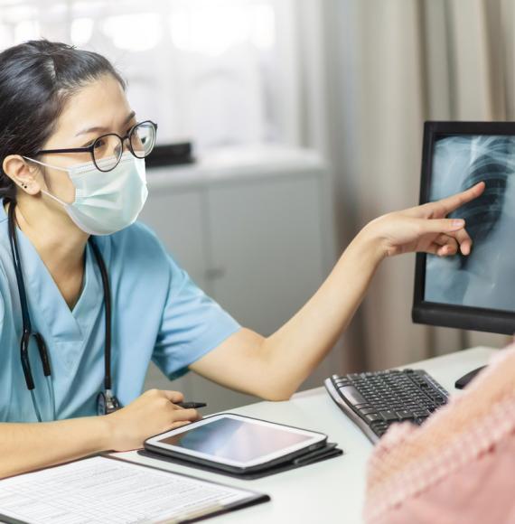 doctor speaking with patient pointing at computer screen