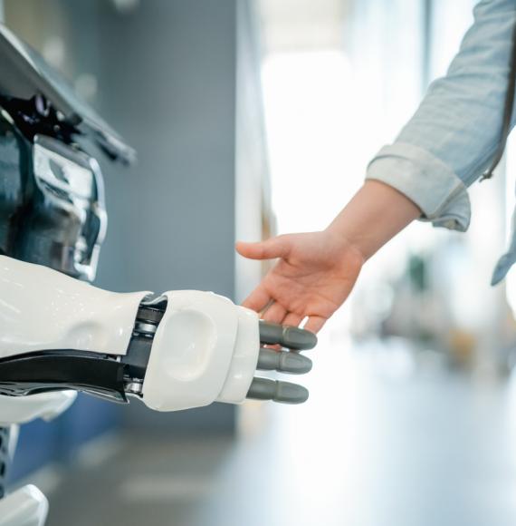 Woman shaking robotic hand