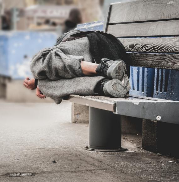 Homeless man sleeping on bench