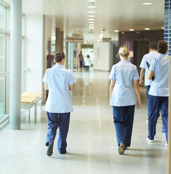 Groups of nurse walking down a corridor depicting the NHS workforce