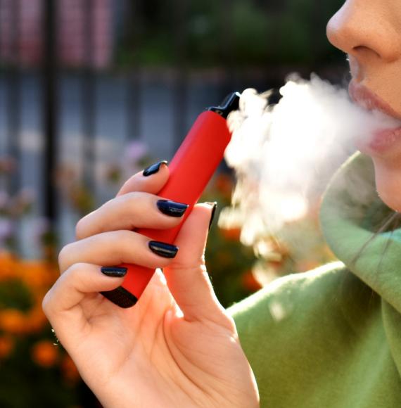 Woman using e-cigarette to try and quit smoking