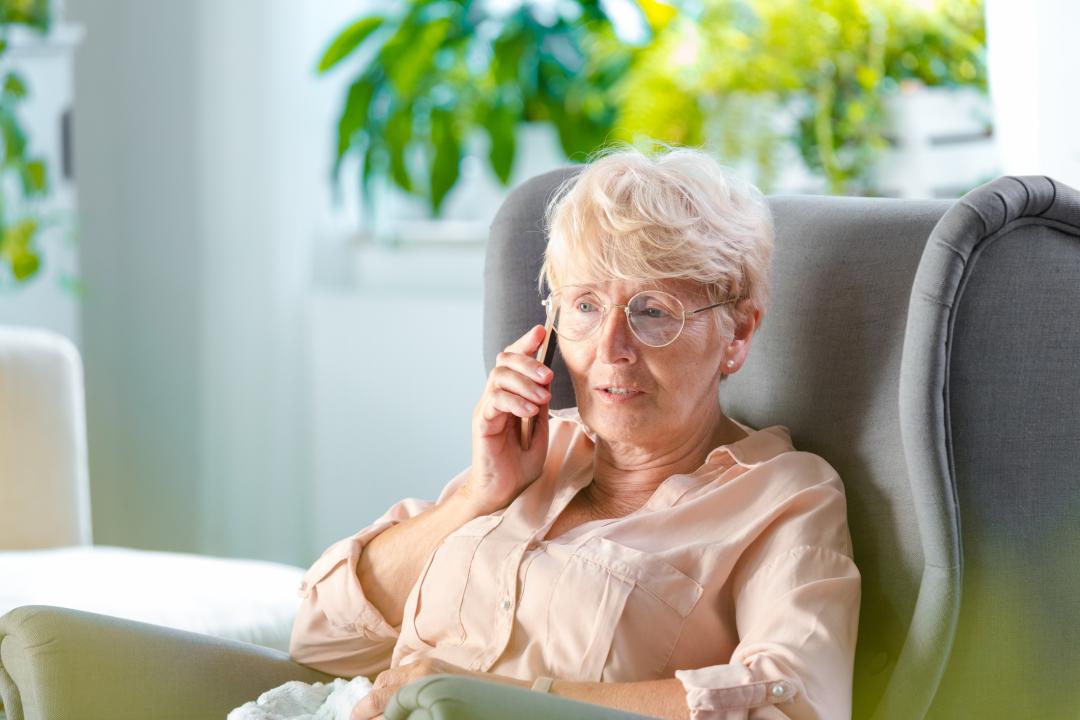 Older woman in a chair talking on the phone