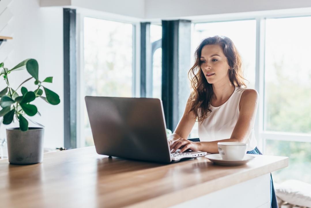 Woman learning remotely from home using her laptop