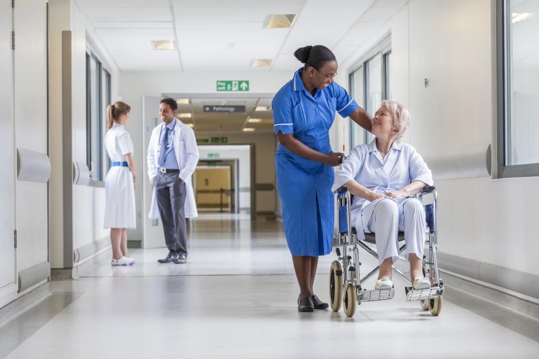 Nurse pushing a patient in a wheelchair