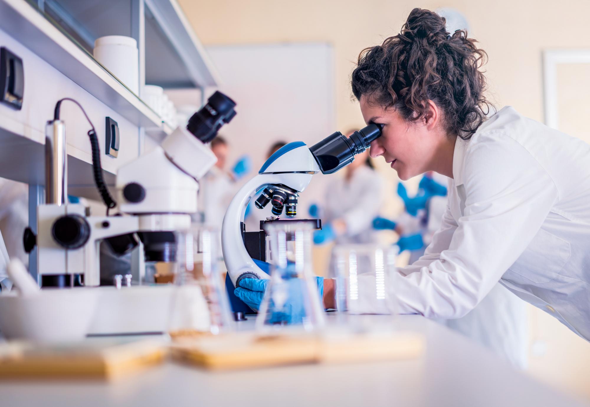 Female scientist looking into microscope