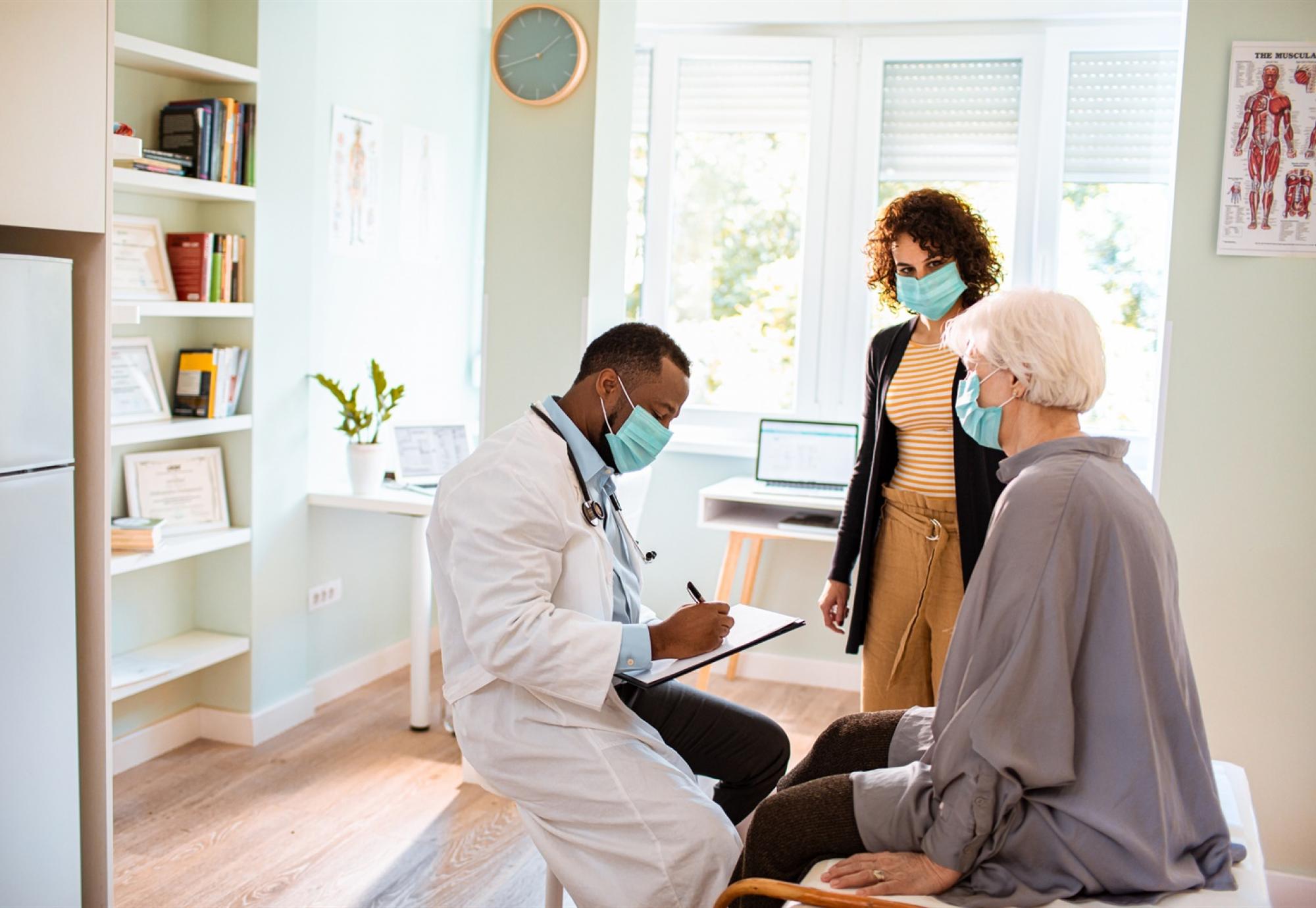 Male doctor discussing with two patients