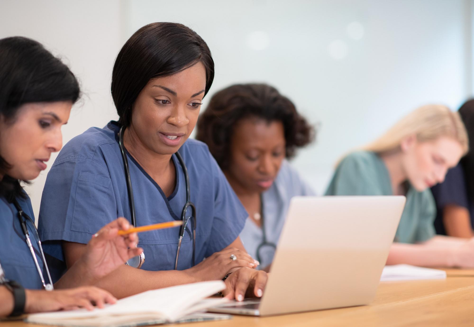 Female nurses studying at laptop