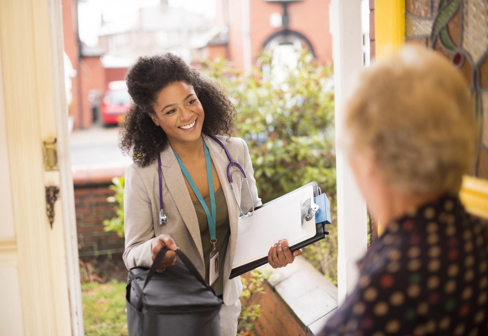 Female doctor visits elderly patient at home. 