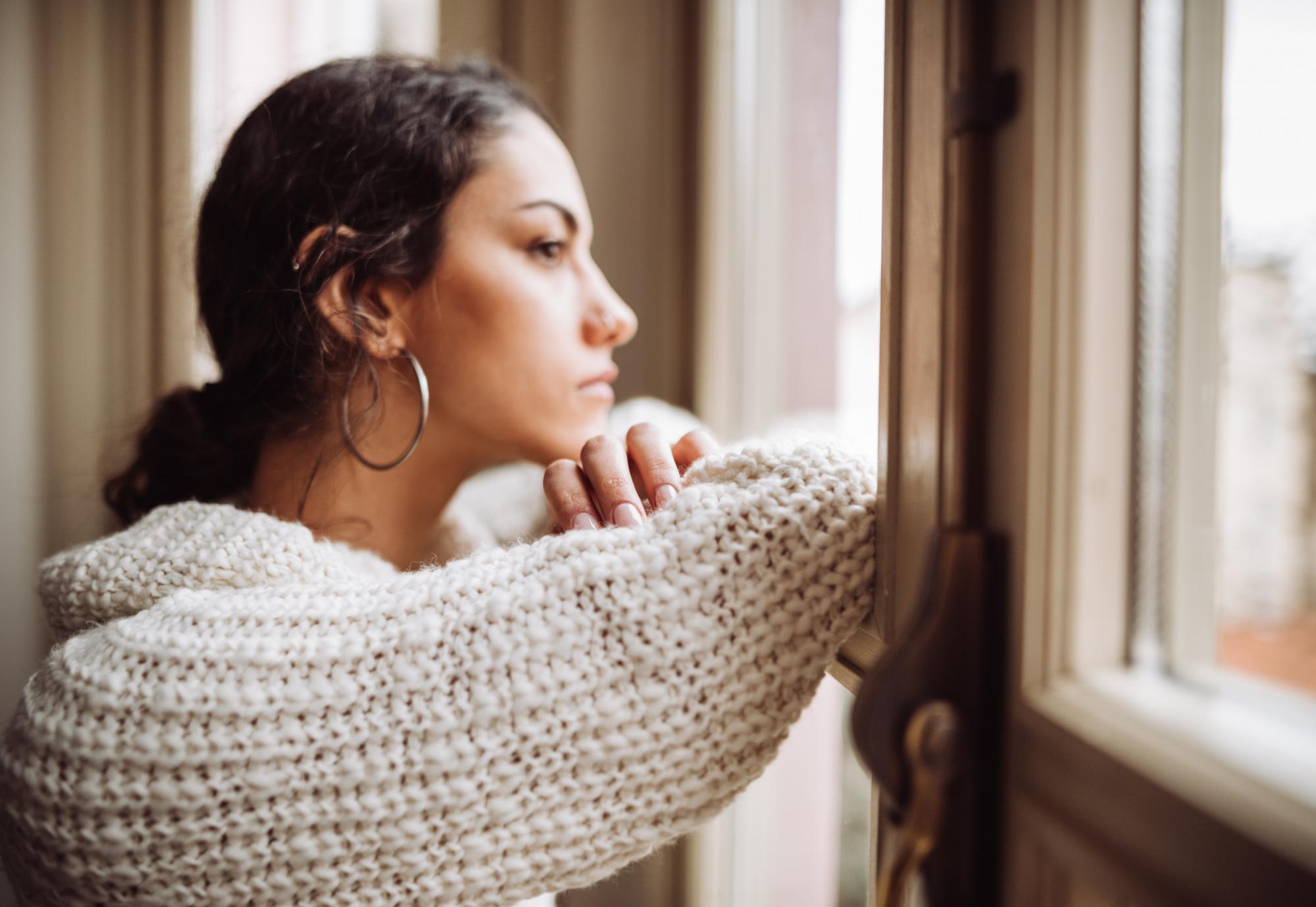 Young woman looking out of a window