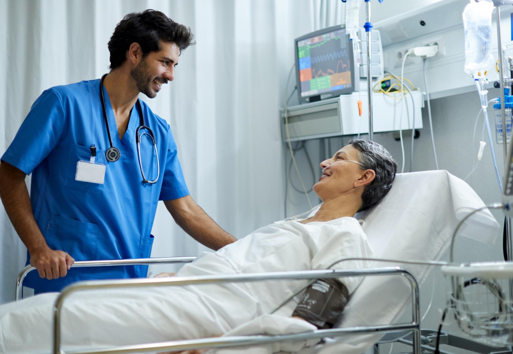 Male health professional at the bedside of a patient