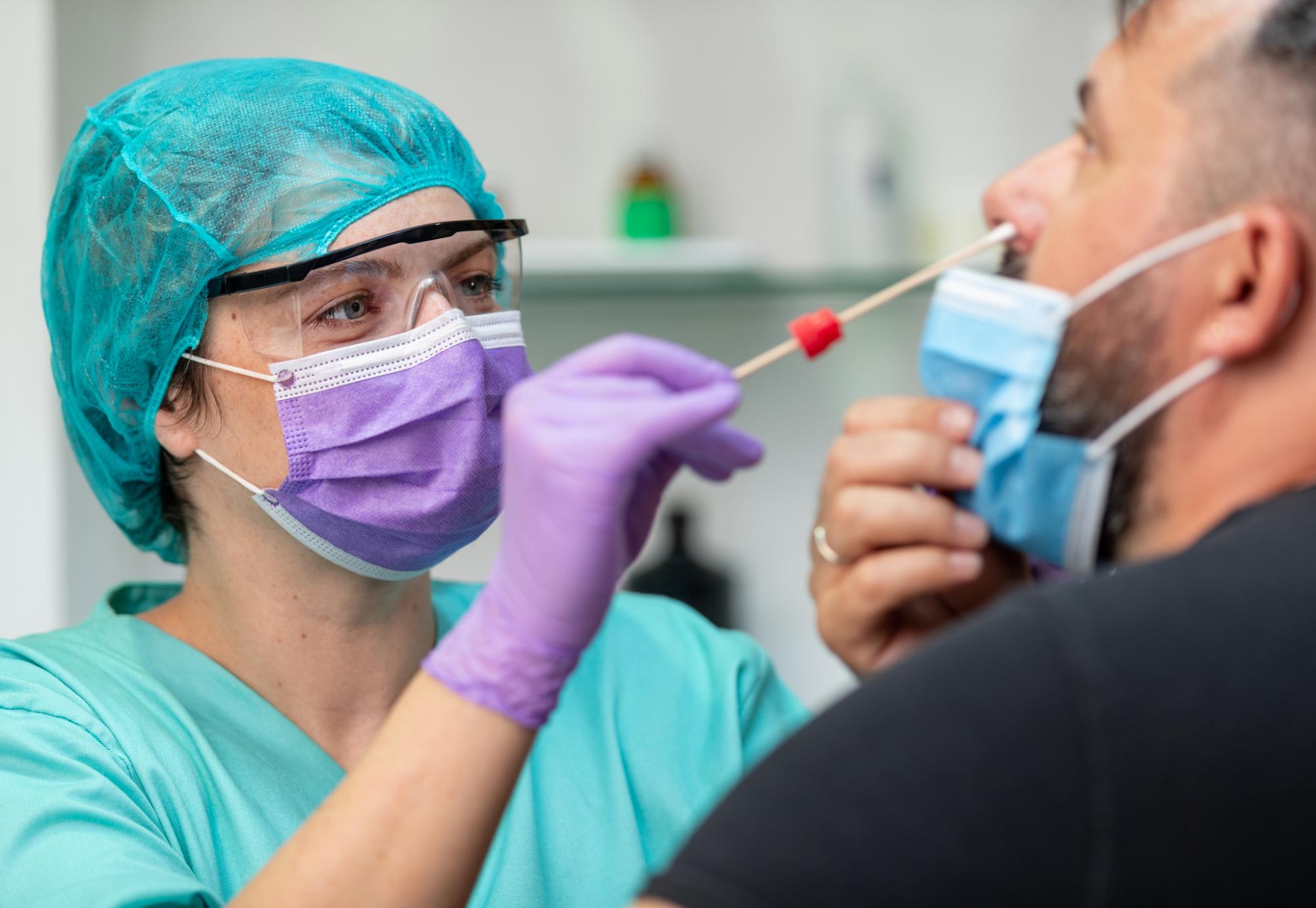 Female health professional carrying out a swab test on a patient