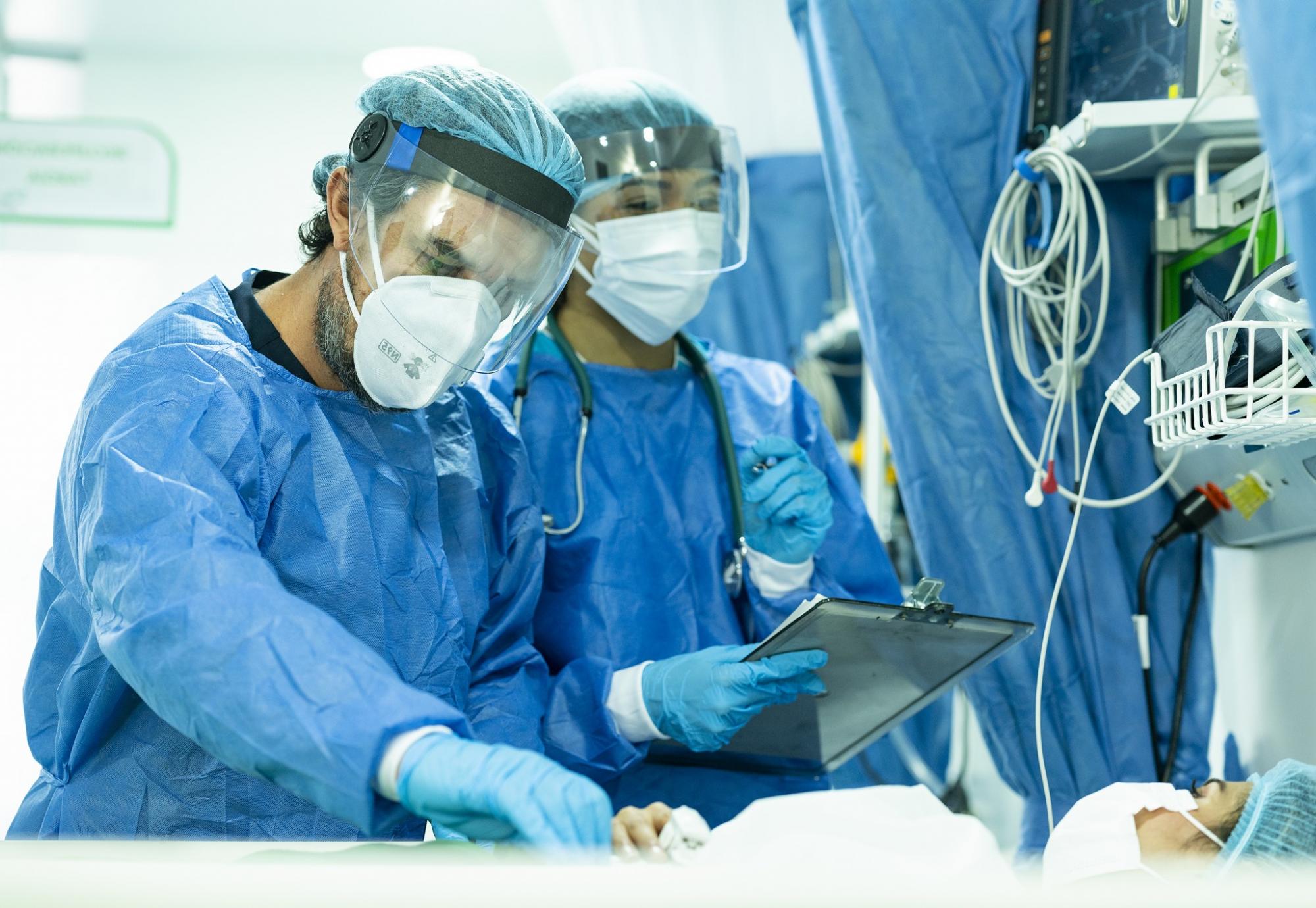 Team of two doctors seeing an inpatient in full protective equipment