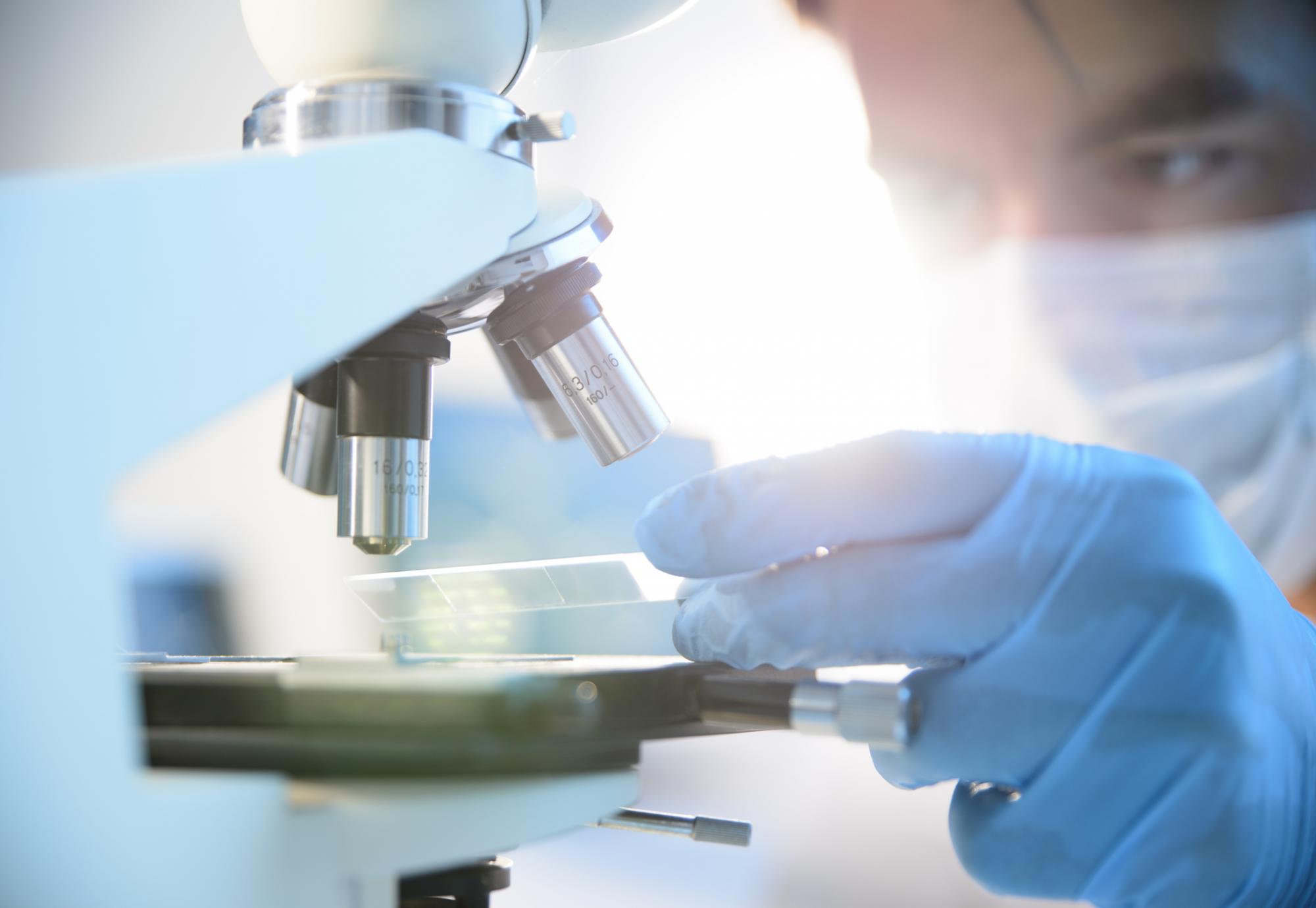 Health researcher using a microscope for research