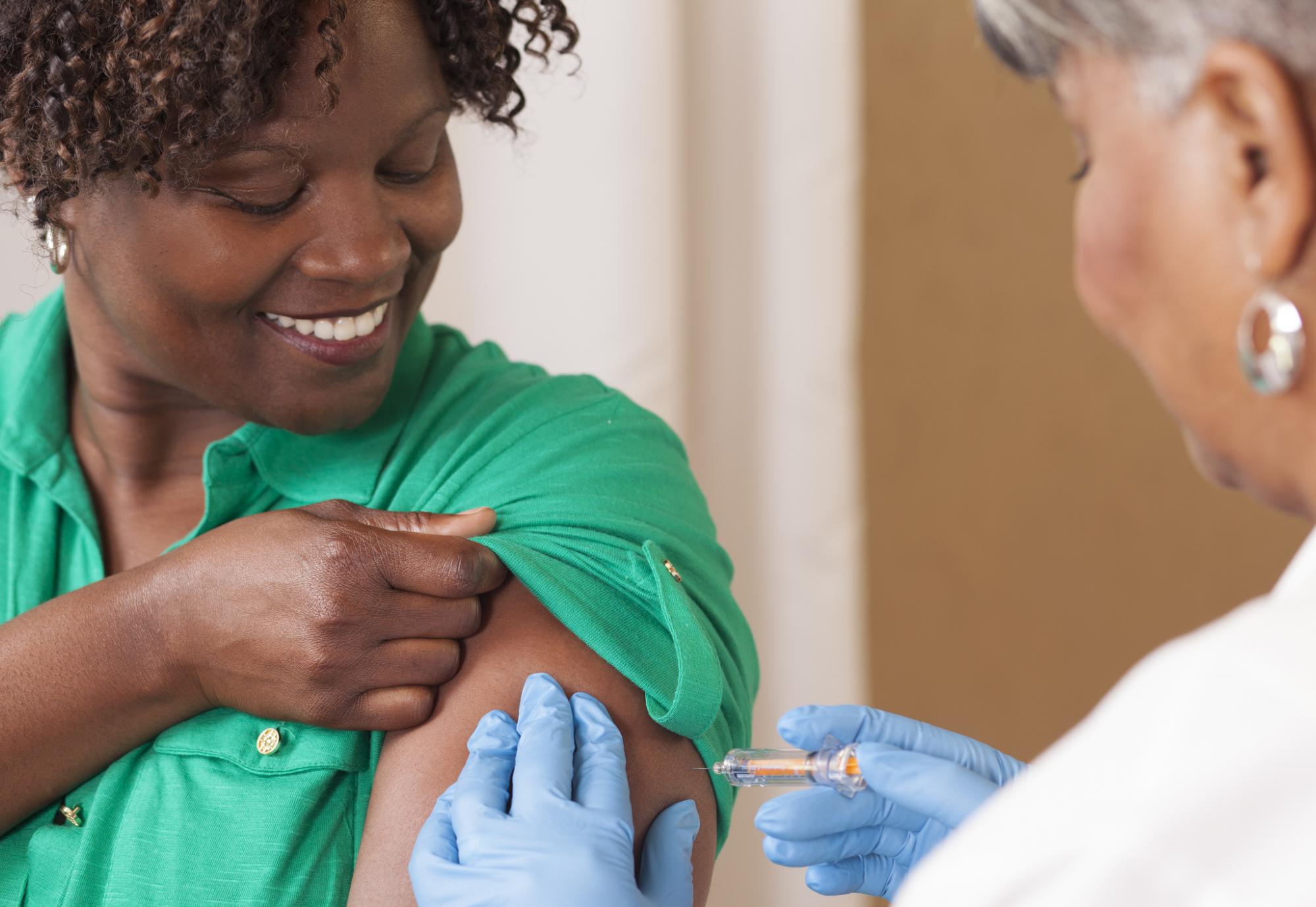 Woman receives a vaccination injection from health professional