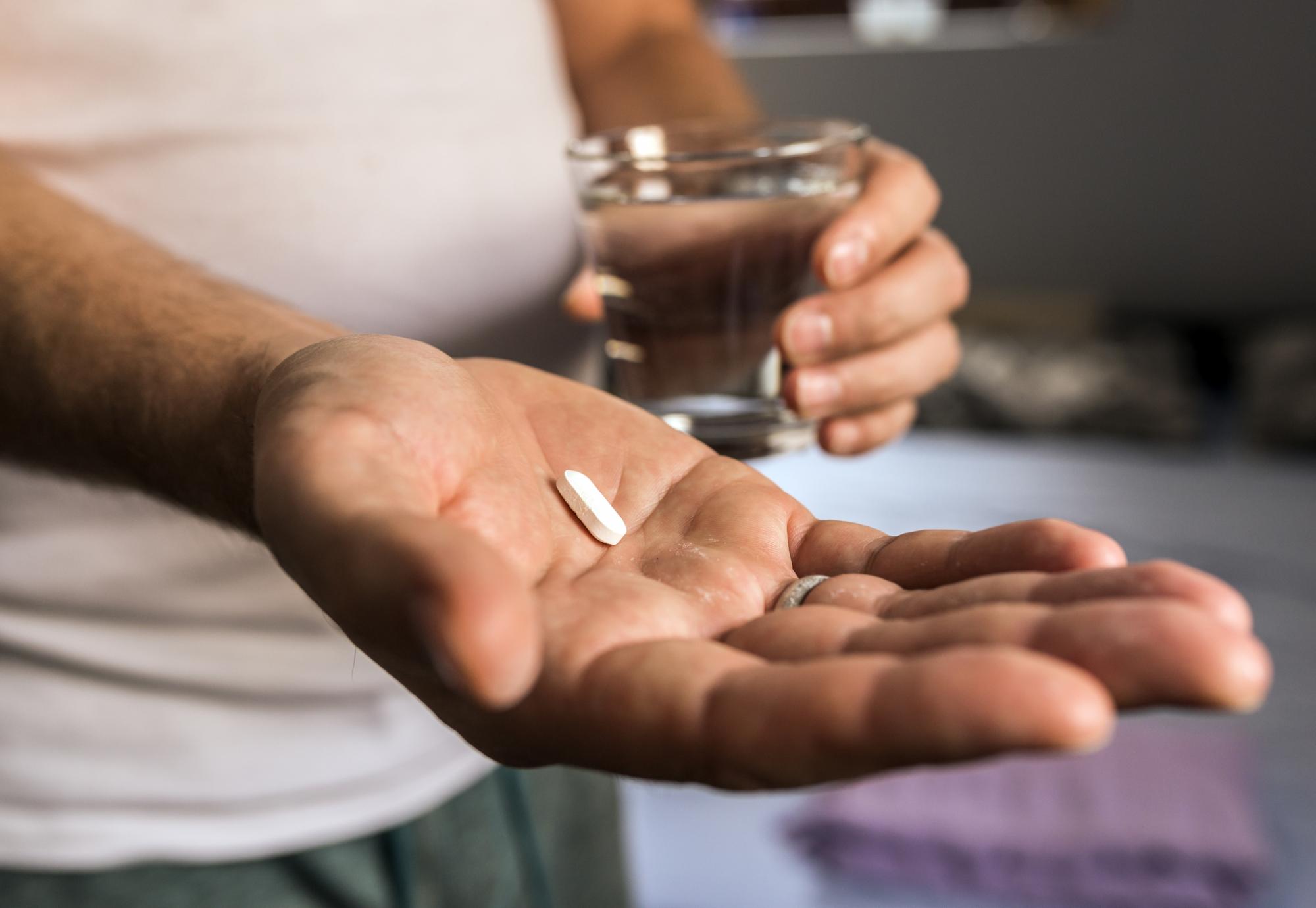 Antibiotic tablet in a man's hand