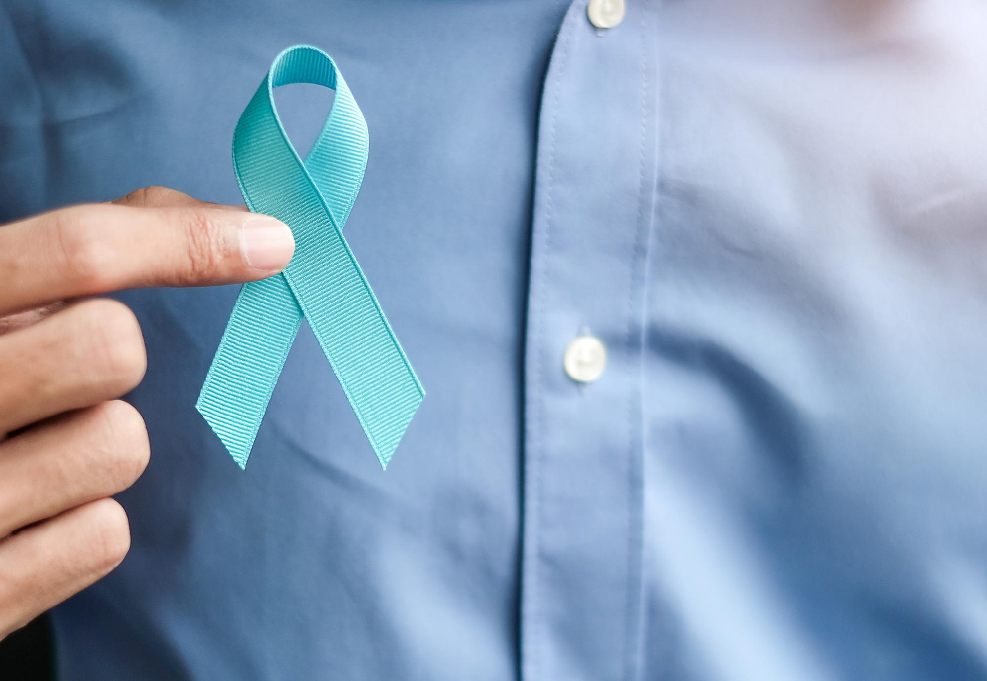 Man holding a blue prostate cancer ribbon
