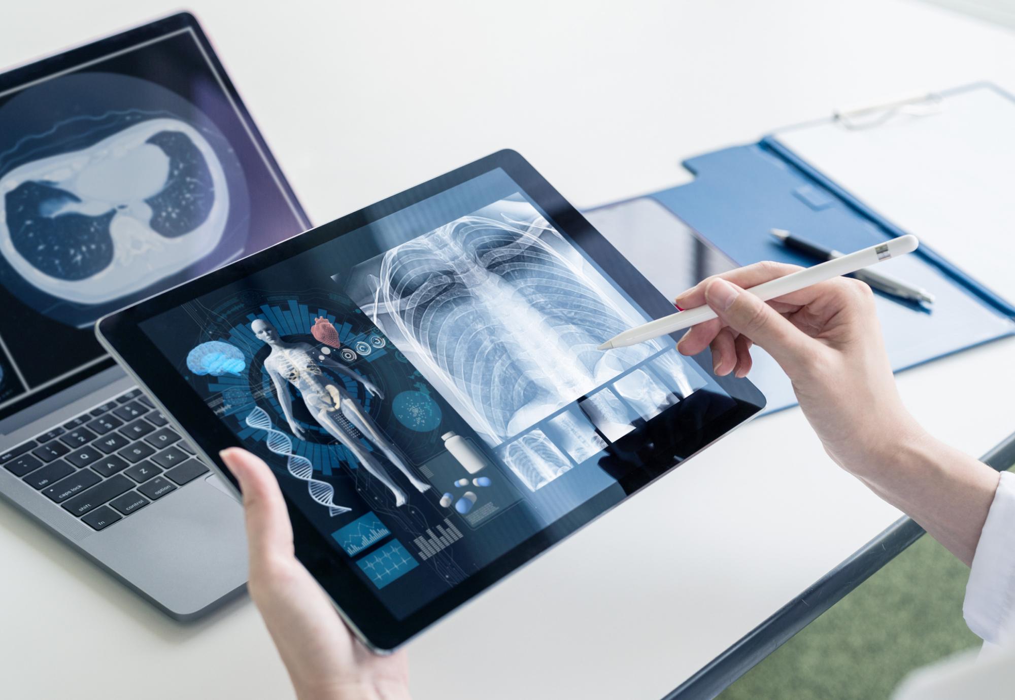 Medical professional using AI/digital solution on tablet and PC