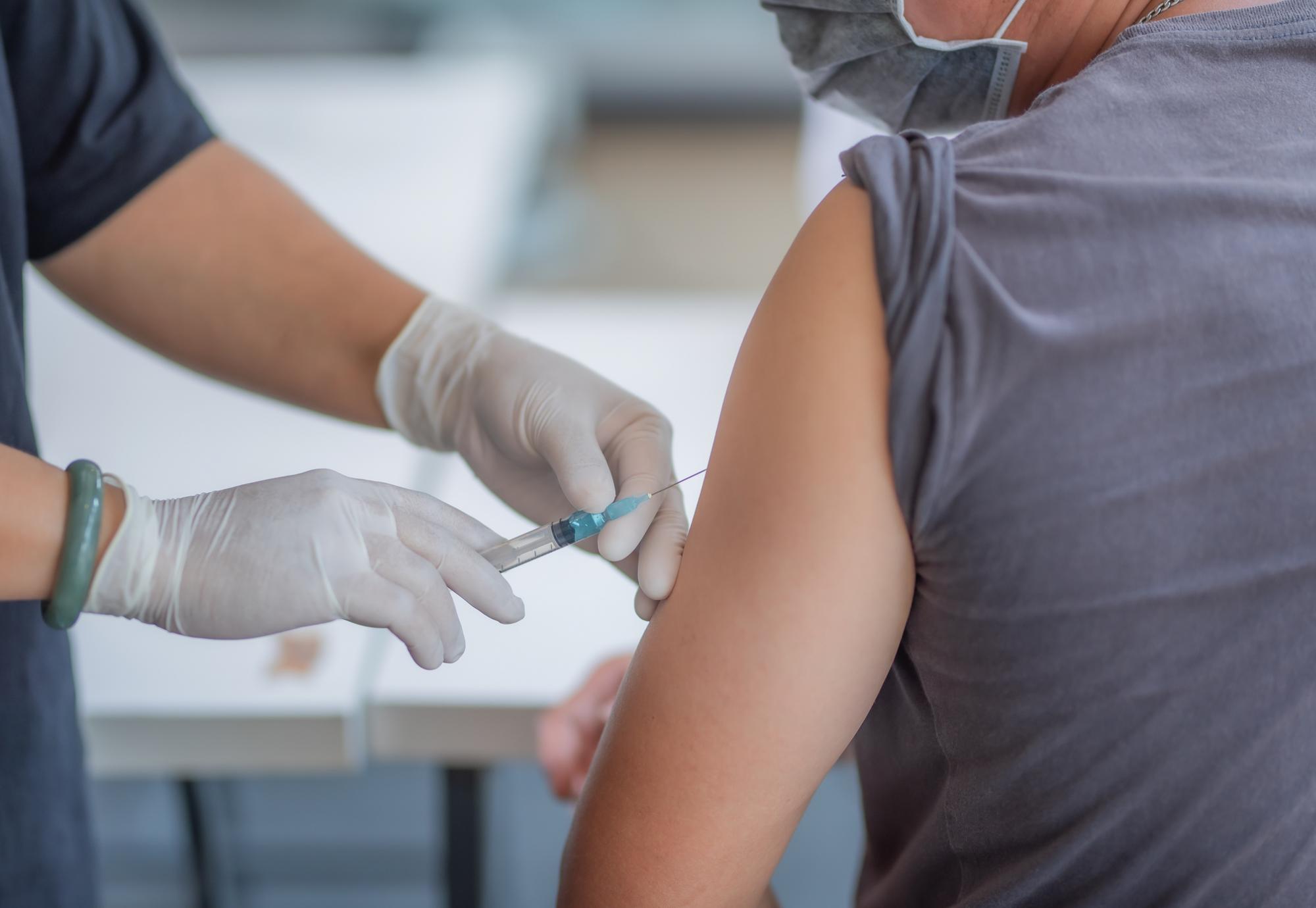 Medical professional administering a vaccine into a patient's arm