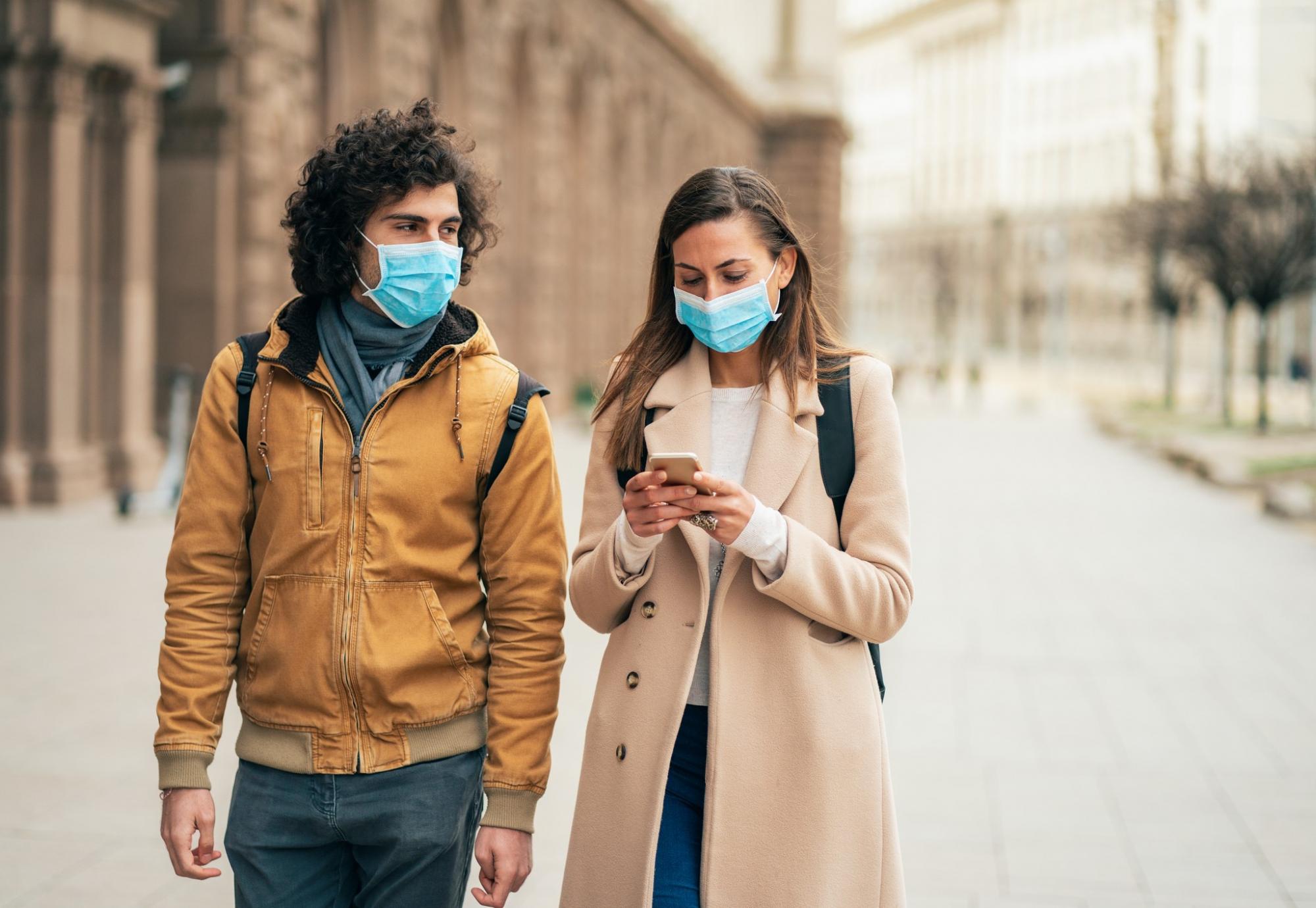 Man and woman wearing face masks walking