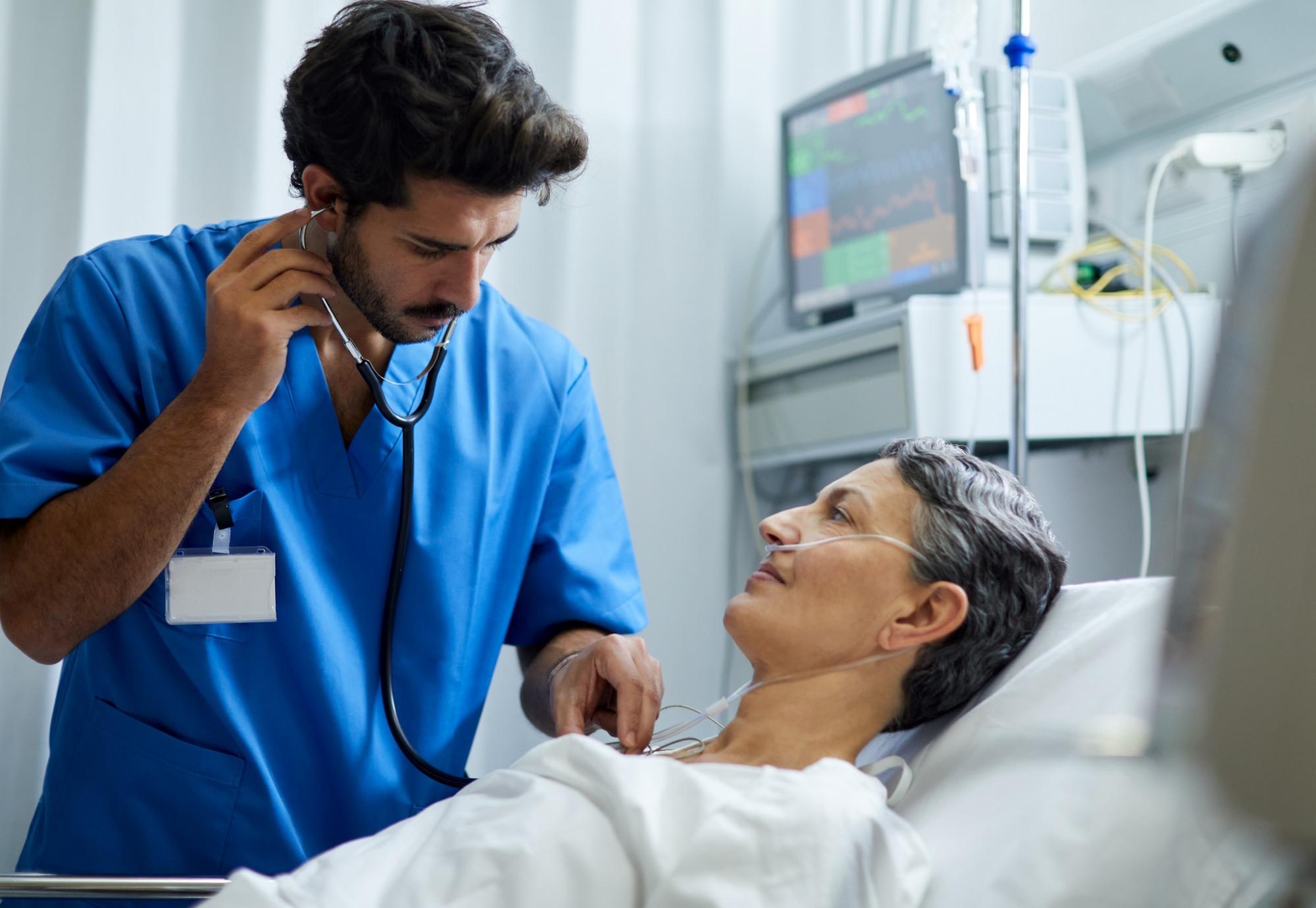 Male health professional listening to a patient with a stethoscope