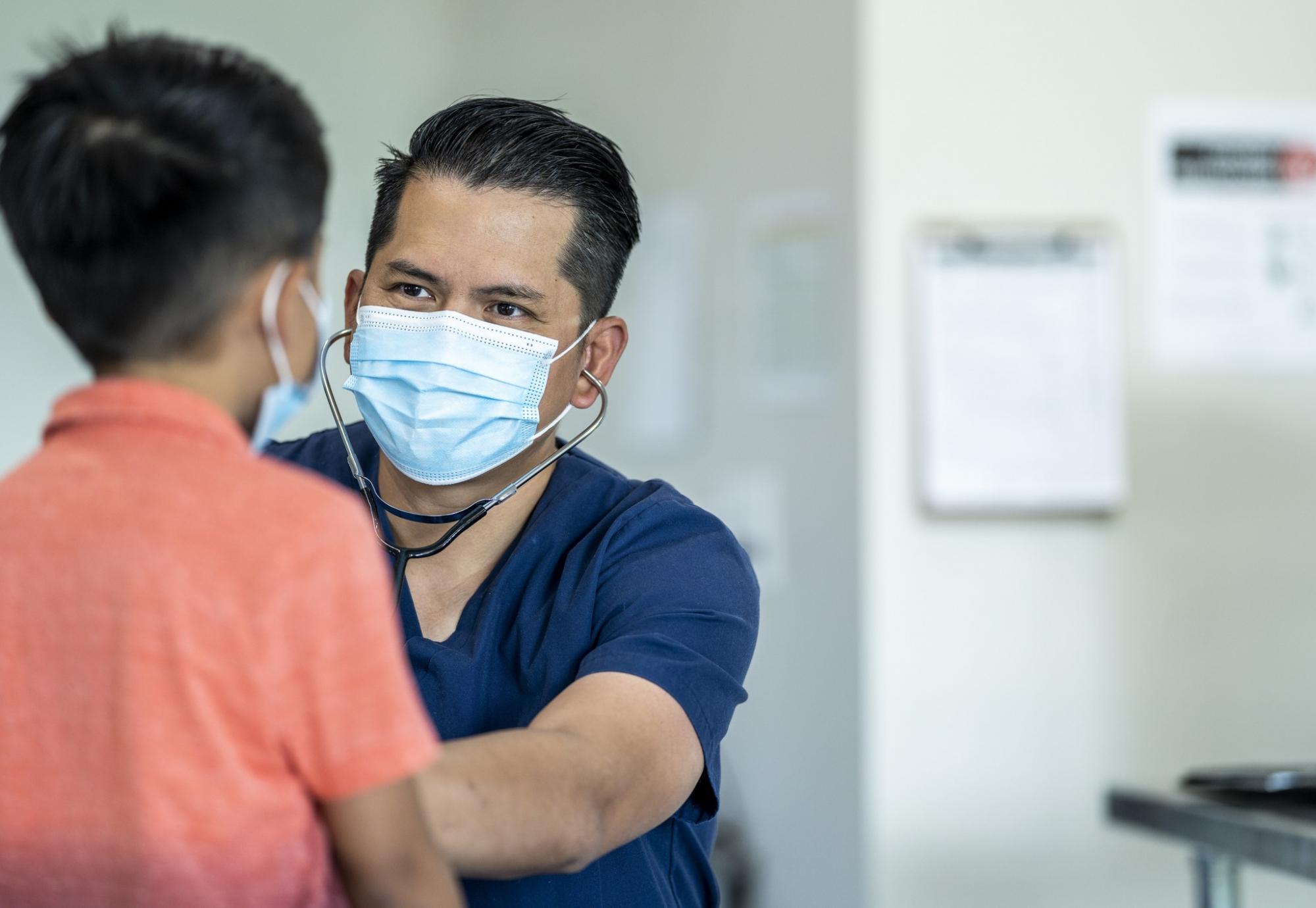 Male doctor examining a young patient