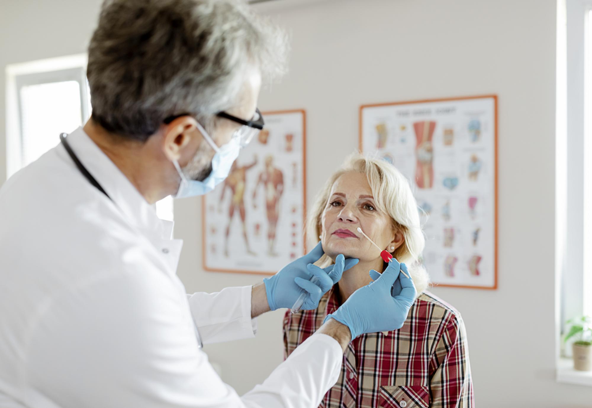 Male doctor performs a nasal swab on a patient