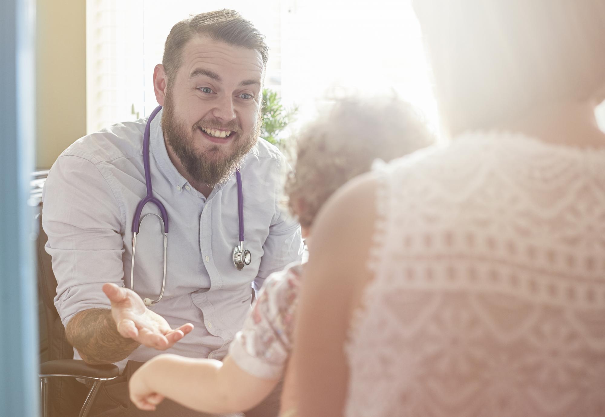 Young male GP talking to a paediatric patient