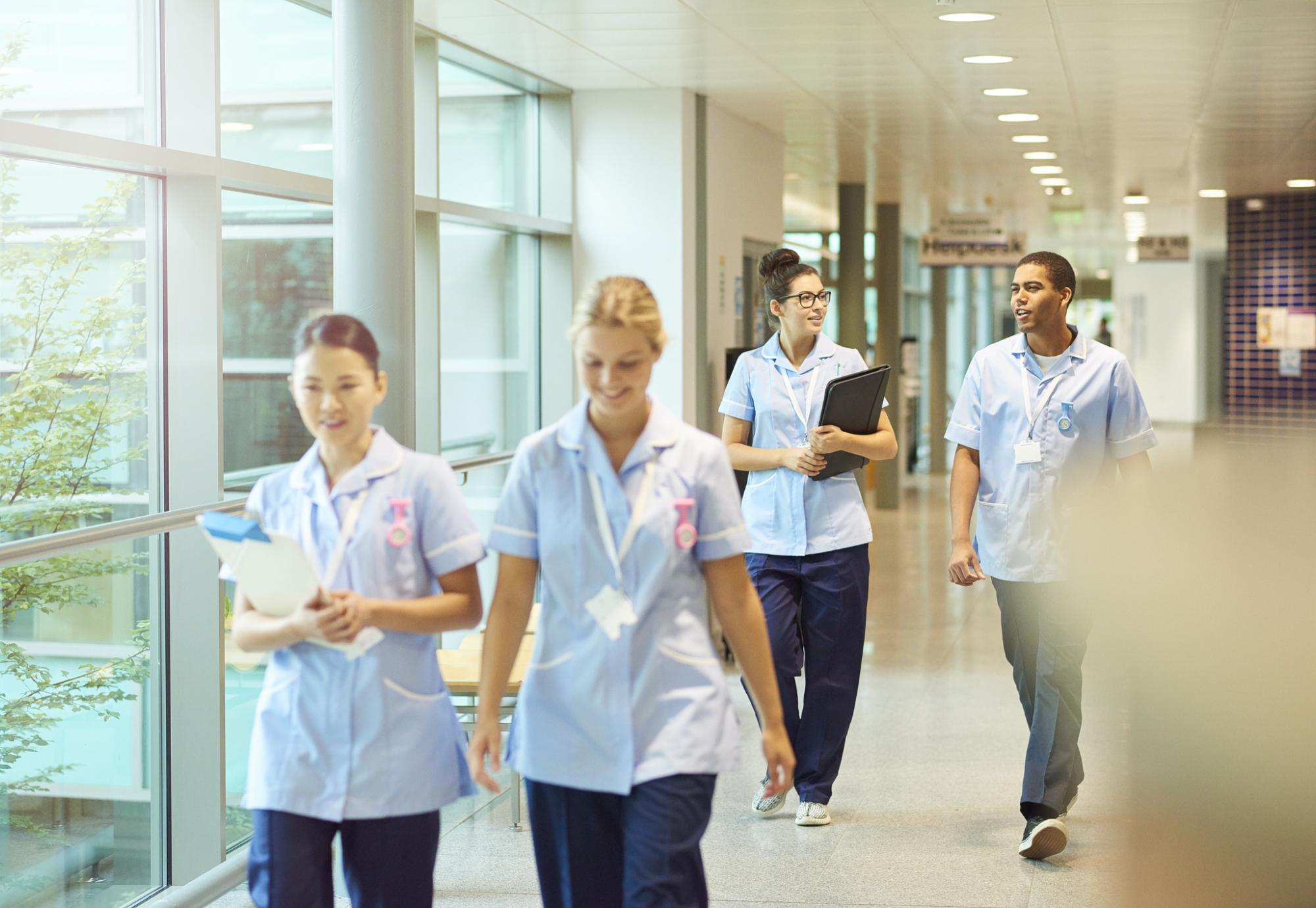 A group of nurses walking through a hospital corridor