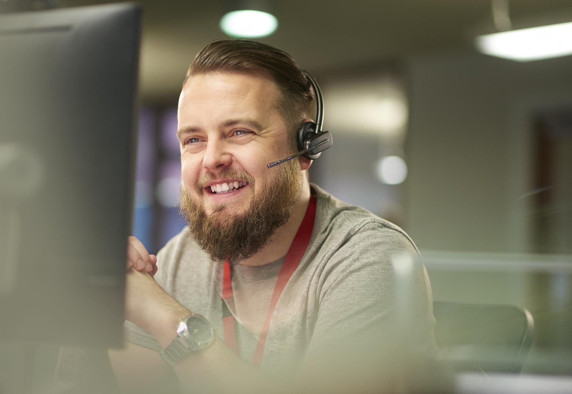 Smiling male call operator talking on a headset