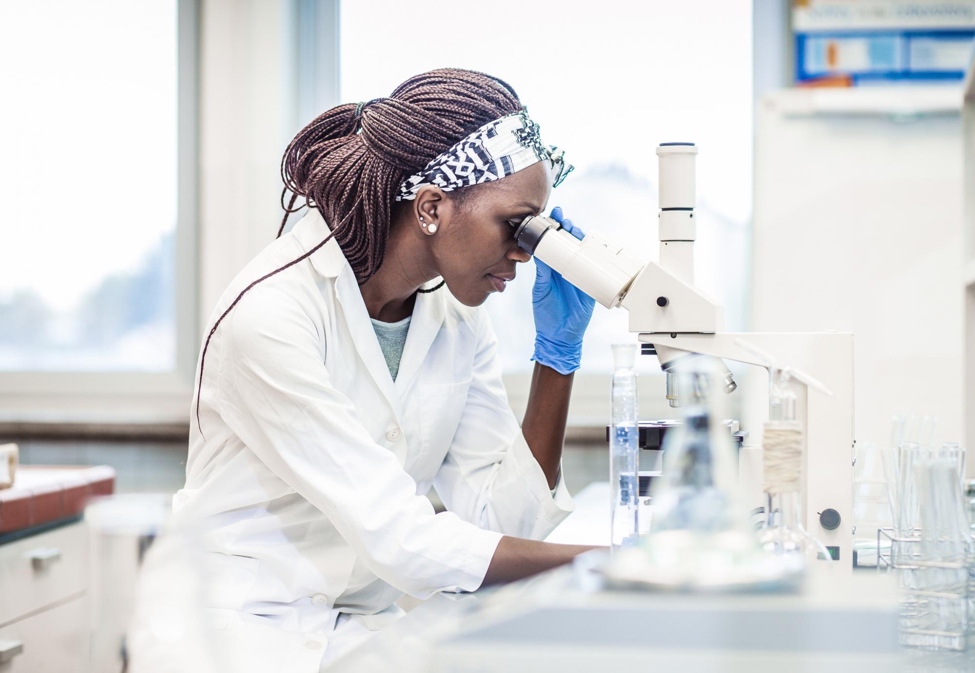 Female scientist looking through a microscope