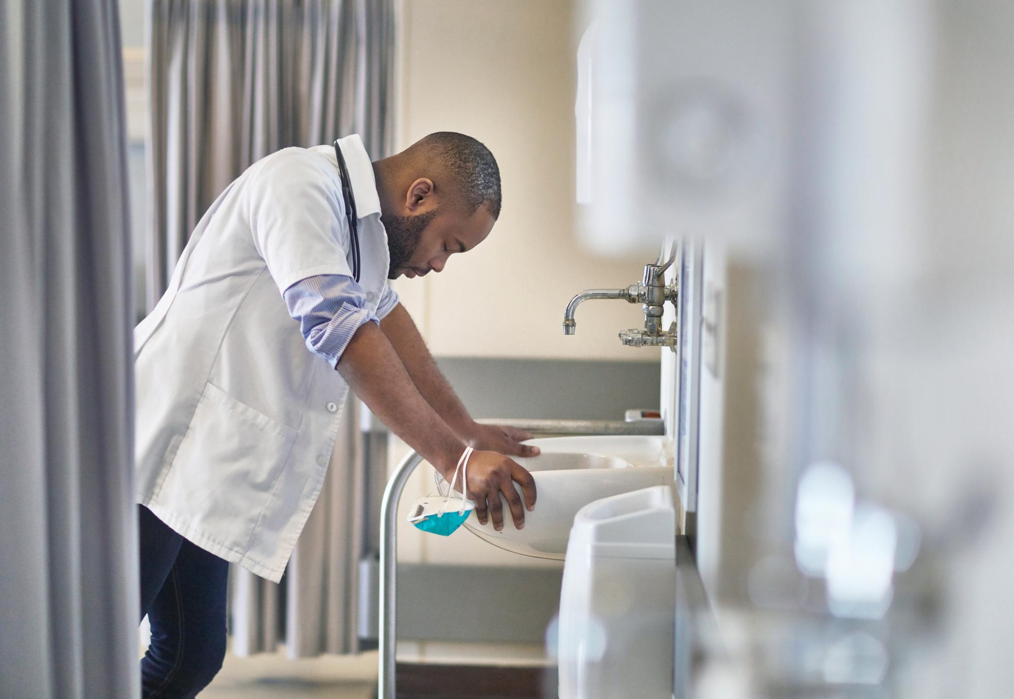 Stressed male doctor takes a moment for reflection